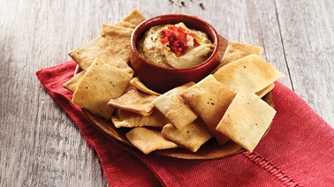 Homemade grilled pepper hummus with multigrain pita chips 