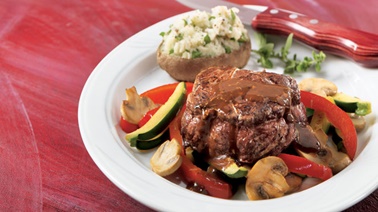 Beef medaillons on a bed of vegetables with red wine sauce