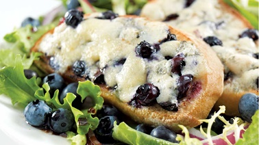 Croûtons au bleu Ermite sucrés aux bleuets sur un lit de verdure